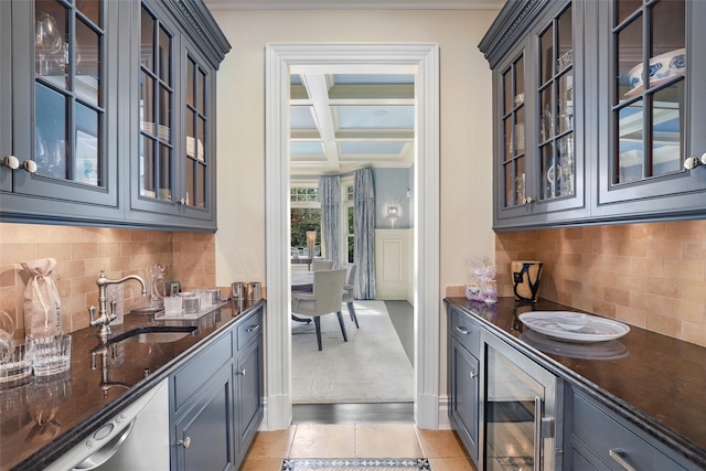 kitchen featuring coffered ceiling, dark stone counters, a sink, glass insert cabinets, and dishwasher