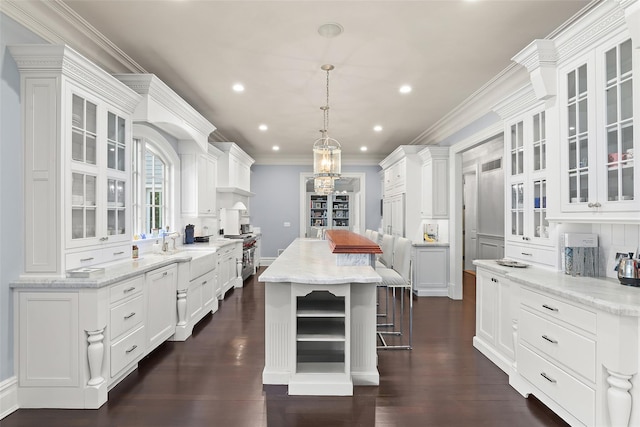 kitchen featuring high end stainless steel range oven, a kitchen island, and white cabinetry