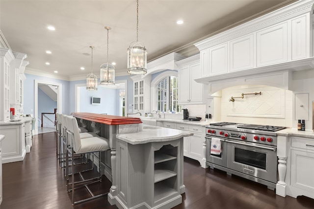 kitchen with a kitchen bar, dark wood finished floors, white cabinetry, range with two ovens, and decorative backsplash