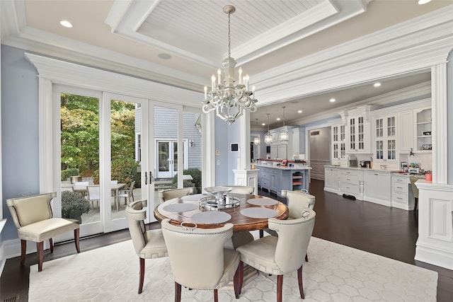 dining space featuring dark wood-style floors, an inviting chandelier, a tray ceiling, ornamental molding, and french doors