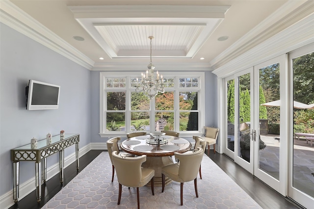 dining space featuring baseboards, a chandelier, dark wood finished floors, a tray ceiling, and ornamental molding