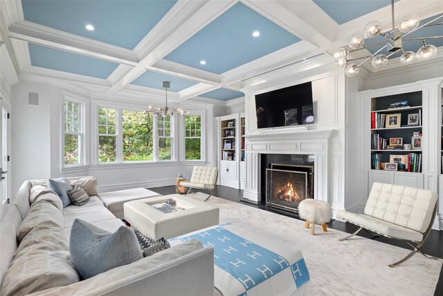 living room featuring a notable chandelier, beamed ceiling, coffered ceiling, and a premium fireplace