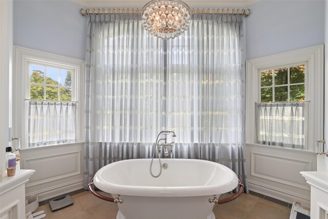 bathroom with tile patterned floors and a freestanding bath