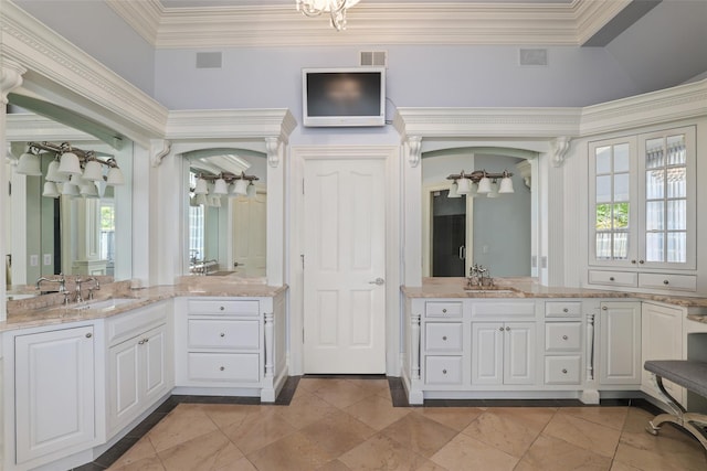 bathroom featuring ornamental molding, a healthy amount of sunlight, and a sink