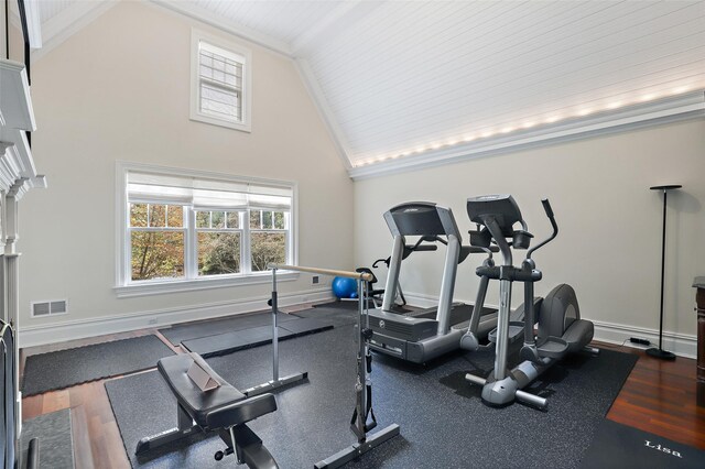 workout area featuring baseboards, visible vents, and high vaulted ceiling