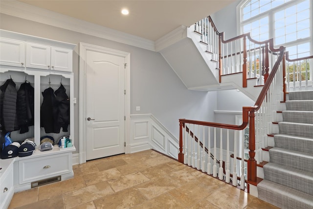 interior space with stone tile floors, visible vents, recessed lighting, and crown molding