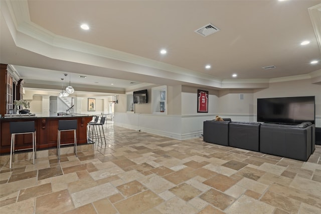 interior space with a raised ceiling, crown molding, visible vents, and stone tile flooring