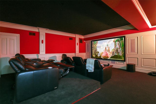 cinema with visible vents, crown molding, carpet, a wainscoted wall, and a decorative wall