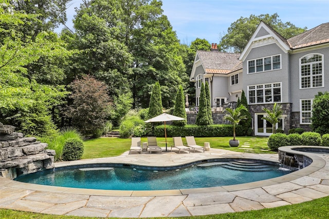 pool with a lawn and a patio area