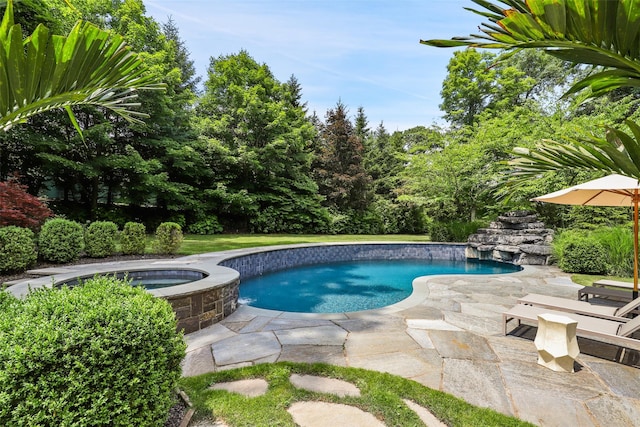 pool featuring a patio area and an in ground hot tub