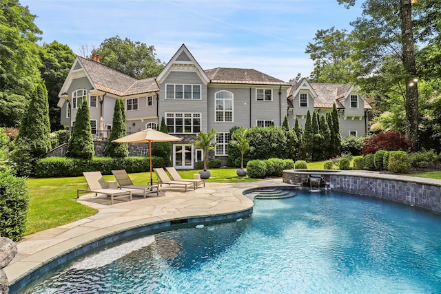 exterior space with an in ground hot tub, a yard, a patio area, and french doors