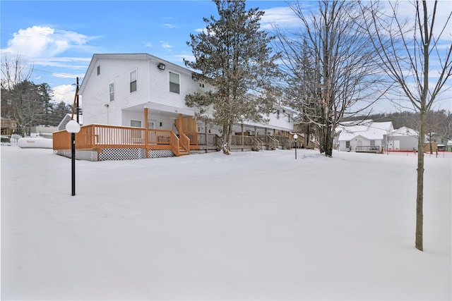 snowy yard featuring a wooden deck