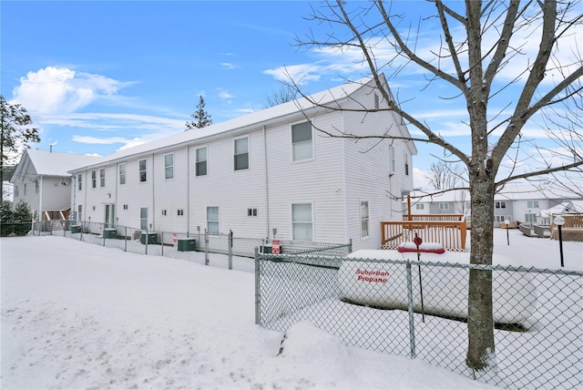 snow covered property with cooling unit