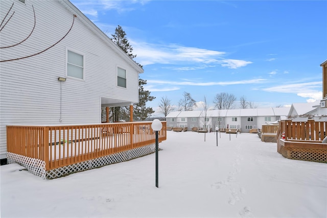 yard layered in snow with a wooden deck