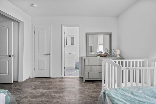 bedroom featuring connected bathroom and dark hardwood / wood-style floors