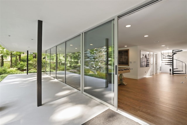 entryway with a wall of windows, billiards, and hardwood / wood-style floors