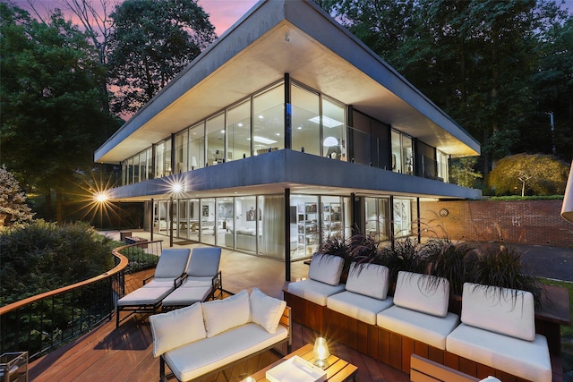 back house at dusk featuring an outdoor hangout area and a patio area