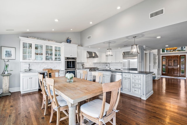 dining space with lofted ceiling, sink, and dark wood-type flooring