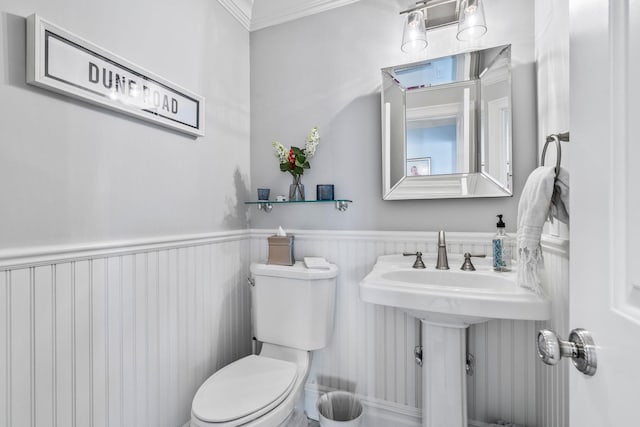 bathroom featuring ornamental molding and toilet