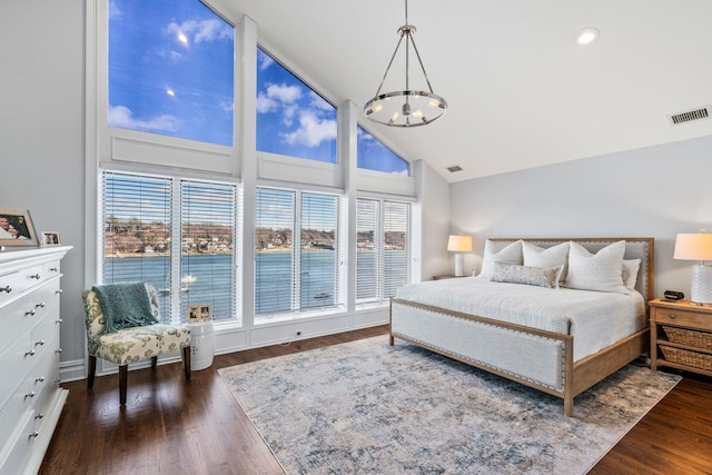 bedroom featuring dark hardwood / wood-style flooring, high vaulted ceiling, and a notable chandelier