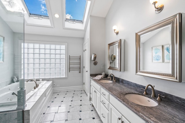 bathroom featuring lofted ceiling with skylight, a relaxing tiled tub, and vanity