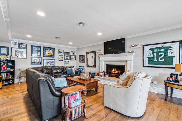 living room with ornamental molding and light hardwood / wood-style floors