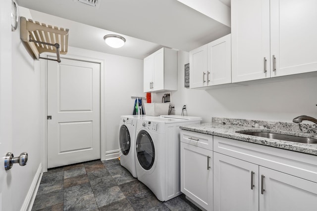 washroom featuring cabinets, sink, and washing machine and clothes dryer