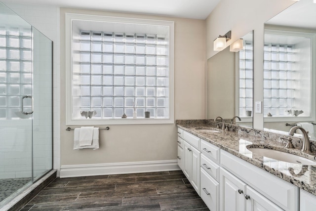 bathroom with hardwood / wood-style flooring, vanity, and an enclosed shower