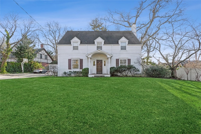 cape cod house featuring a front yard