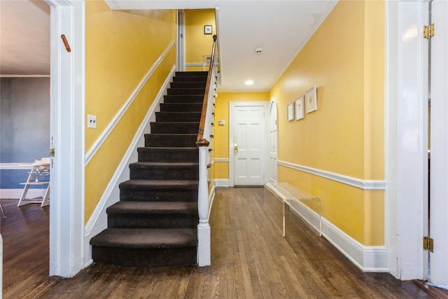 stairs featuring crown molding and hardwood / wood-style floors