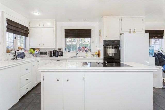 kitchen featuring sink, white cabinets, and black appliances