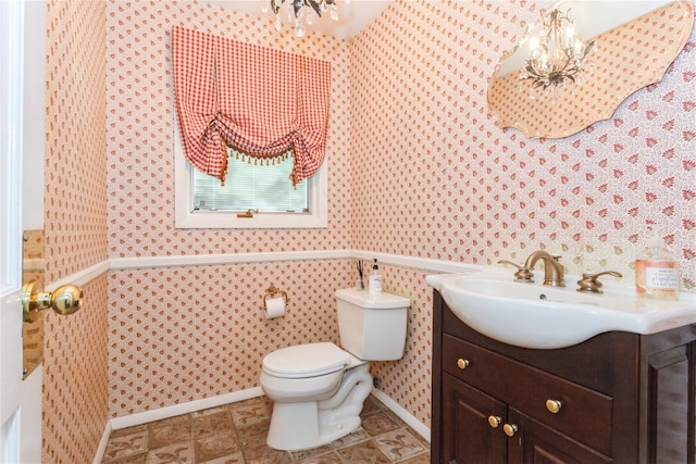 bathroom with toilet, vanity, and an inviting chandelier