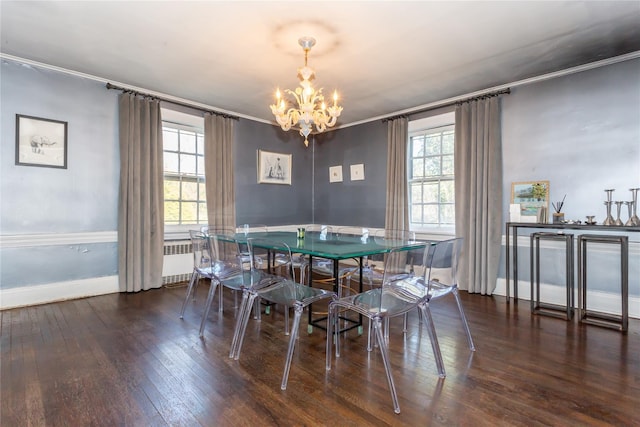 dining space featuring dark wood-type flooring, radiator, a notable chandelier, and ornamental molding