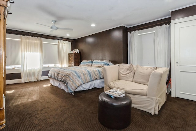 bedroom featuring ceiling fan, ornamental molding, and dark colored carpet