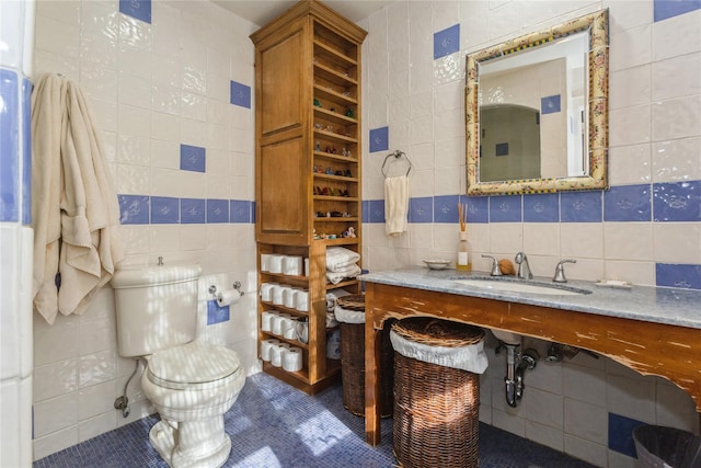 bathroom featuring sink, tile walls, toilet, and tile patterned flooring