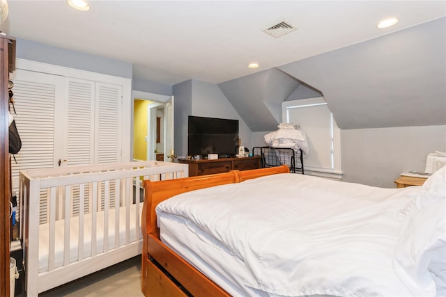 bedroom with light carpet, a closet, and lofted ceiling