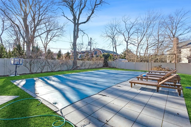 view of swimming pool with a lawn, a patio area, and basketball hoop