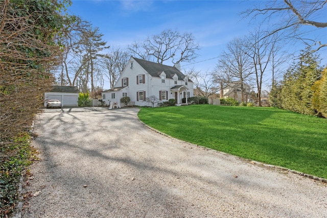 view of side of home with a garage, a yard, and an outbuilding