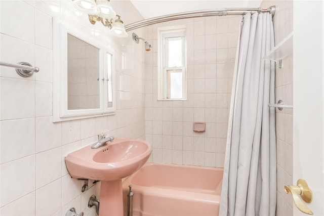 bathroom with sink, tile walls, and shower / bath combo