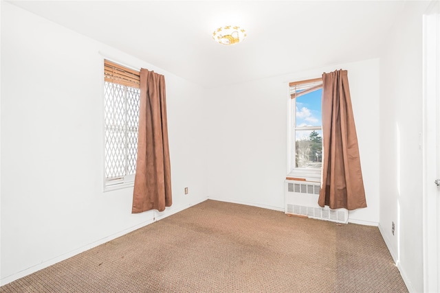 spare room featuring radiator and carpet floors