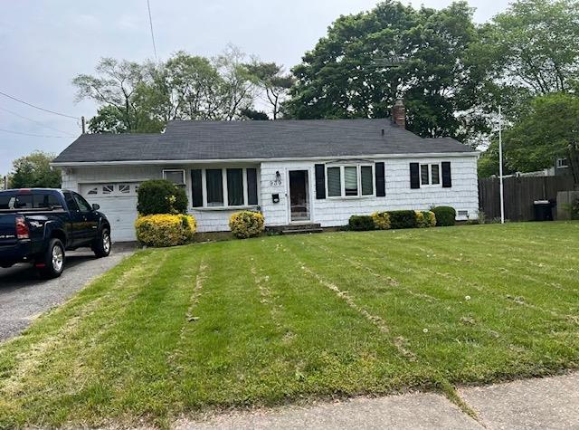 single story home featuring a front lawn and a garage