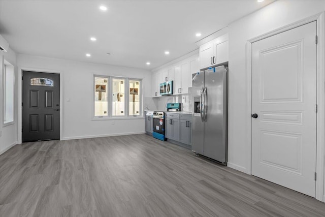 kitchen featuring white cabinetry, stainless steel appliances, and light hardwood / wood-style flooring