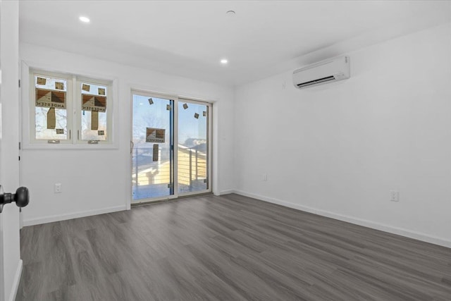 empty room with a wall mounted air conditioner and dark wood-type flooring