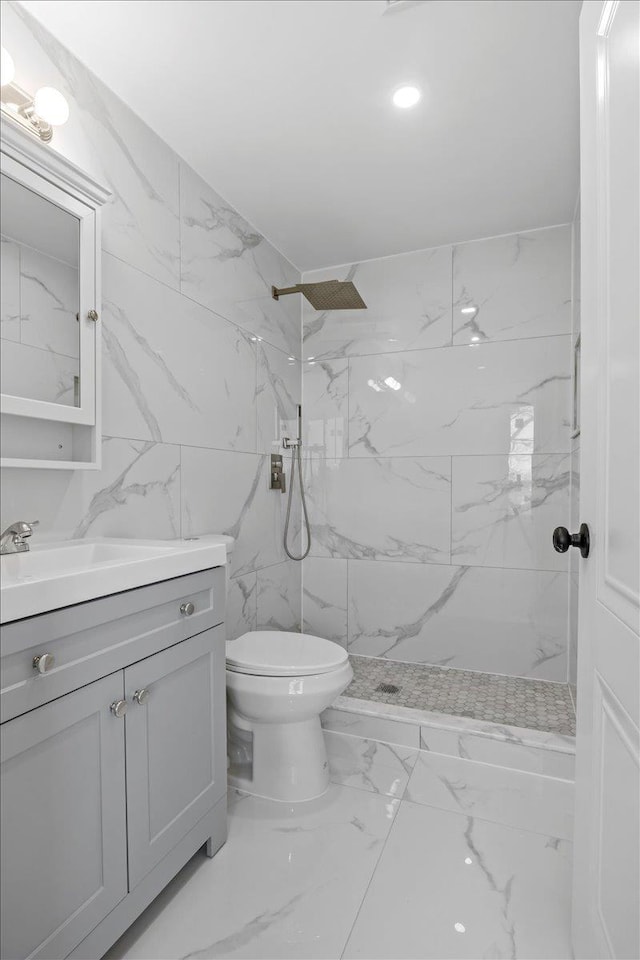 bathroom featuring vanity, toilet, and a tile shower