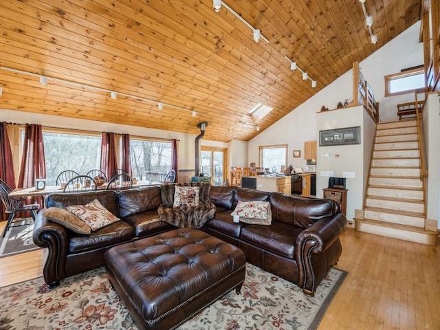 living room with wood ceiling, rail lighting, high vaulted ceiling, and light wood-type flooring