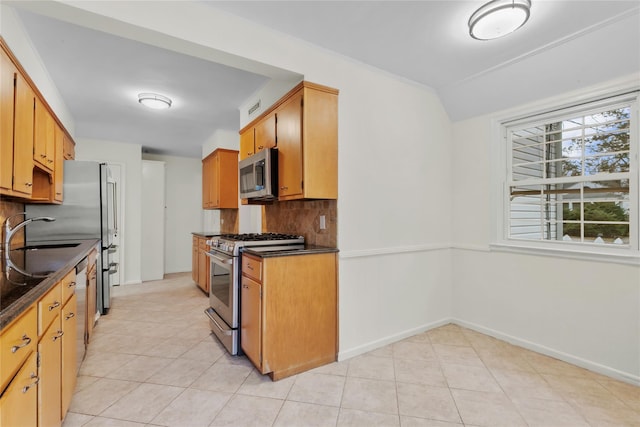 kitchen featuring light tile patterned floors, stainless steel appliances, tasteful backsplash, and sink