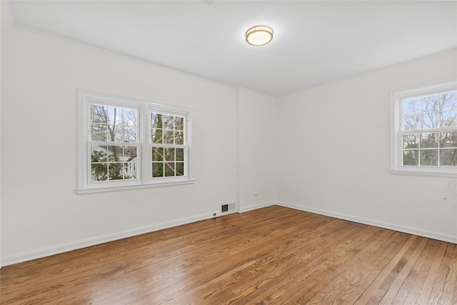 empty room with plenty of natural light and wood-type flooring