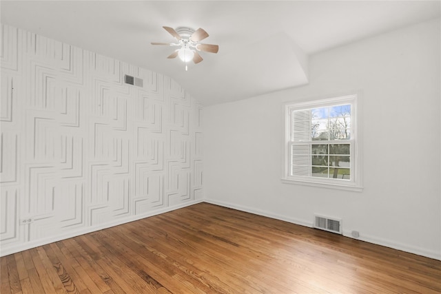 unfurnished bedroom featuring ceiling fan, hardwood / wood-style flooring, a closet, and vaulted ceiling