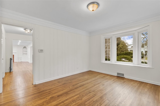 spare room with ornamental molding and hardwood / wood-style flooring