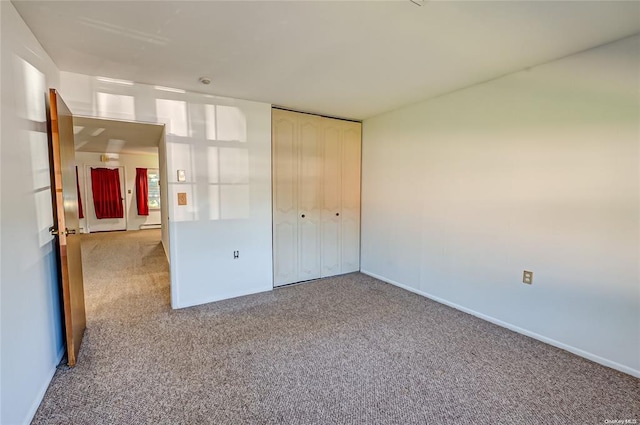 unfurnished bedroom with light carpet and a closet